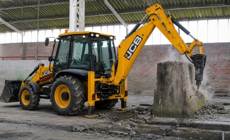 экскаватор-погрузчик JCB с гидромолотом на демонтажных работах