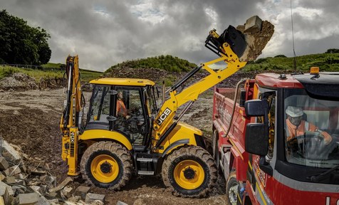 экскаватор-погрузчик JCB 4CX грузит самосвал
